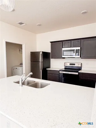 a kitchen with granite countertop a refrigerator and a stove