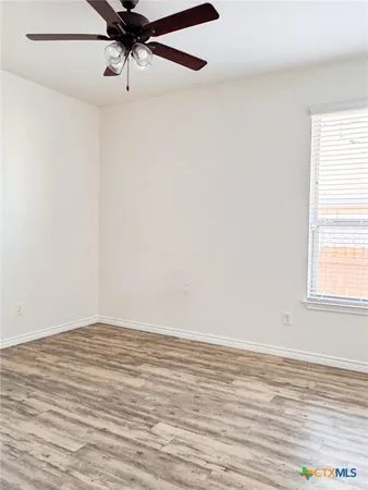 an empty room with a window and a ceiling fan