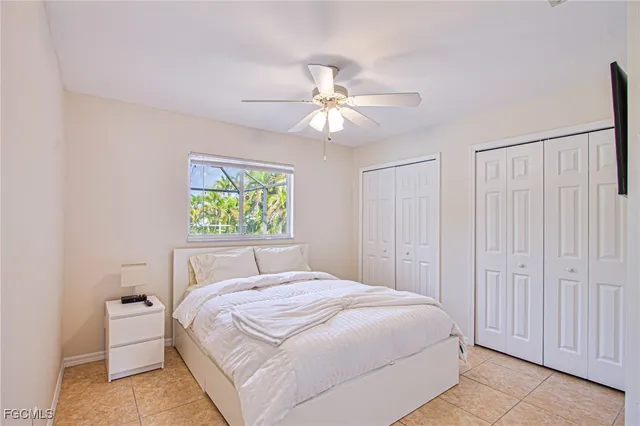 a bedroom with a large bed and a chandelier fan