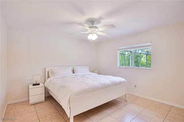 a bedroom with a bed and a ceiling fan