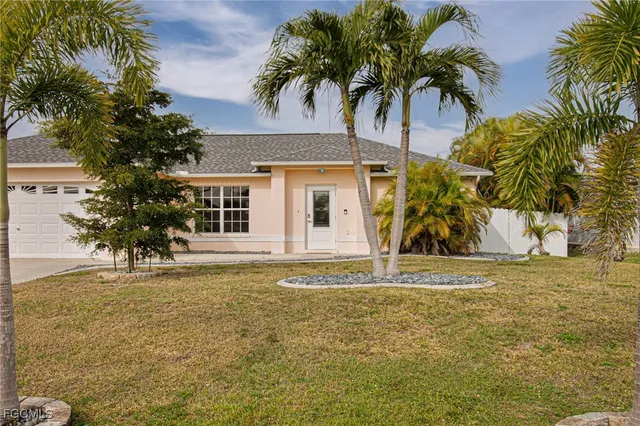 a view of a white house with a large window and palm trees