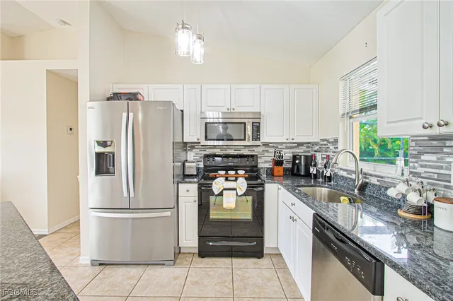 a kitchen with a refrigerator stove microwave and sink