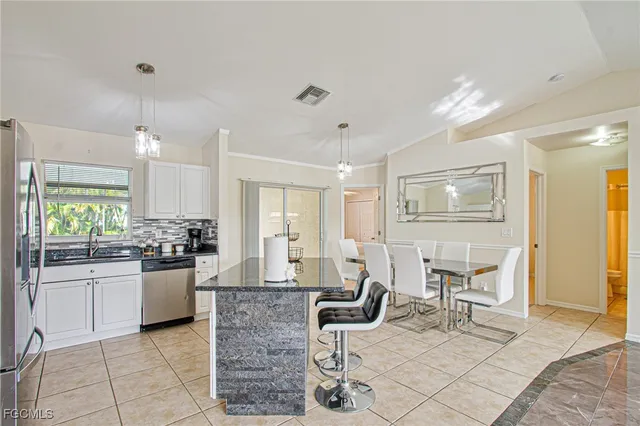 a kitchen with a dining table chairs and white cabinets
