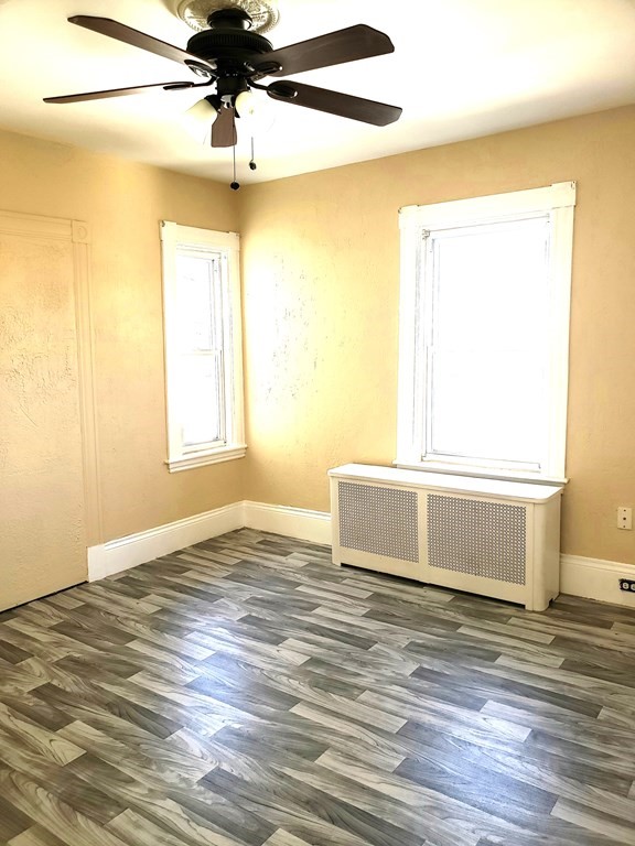 63 Irving Street Everett, MA 02149 - Photo 6 of 8 a view of an empty room with a window and wooden floor