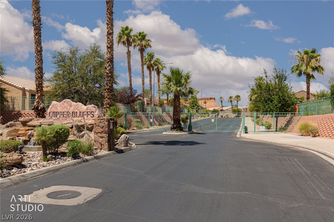 387 Silver Road Mesquite, NV 89027 - Photo 38 of 46 Secure gated entry welcomes residents home along a palm-lined paved drive under desert skies.
