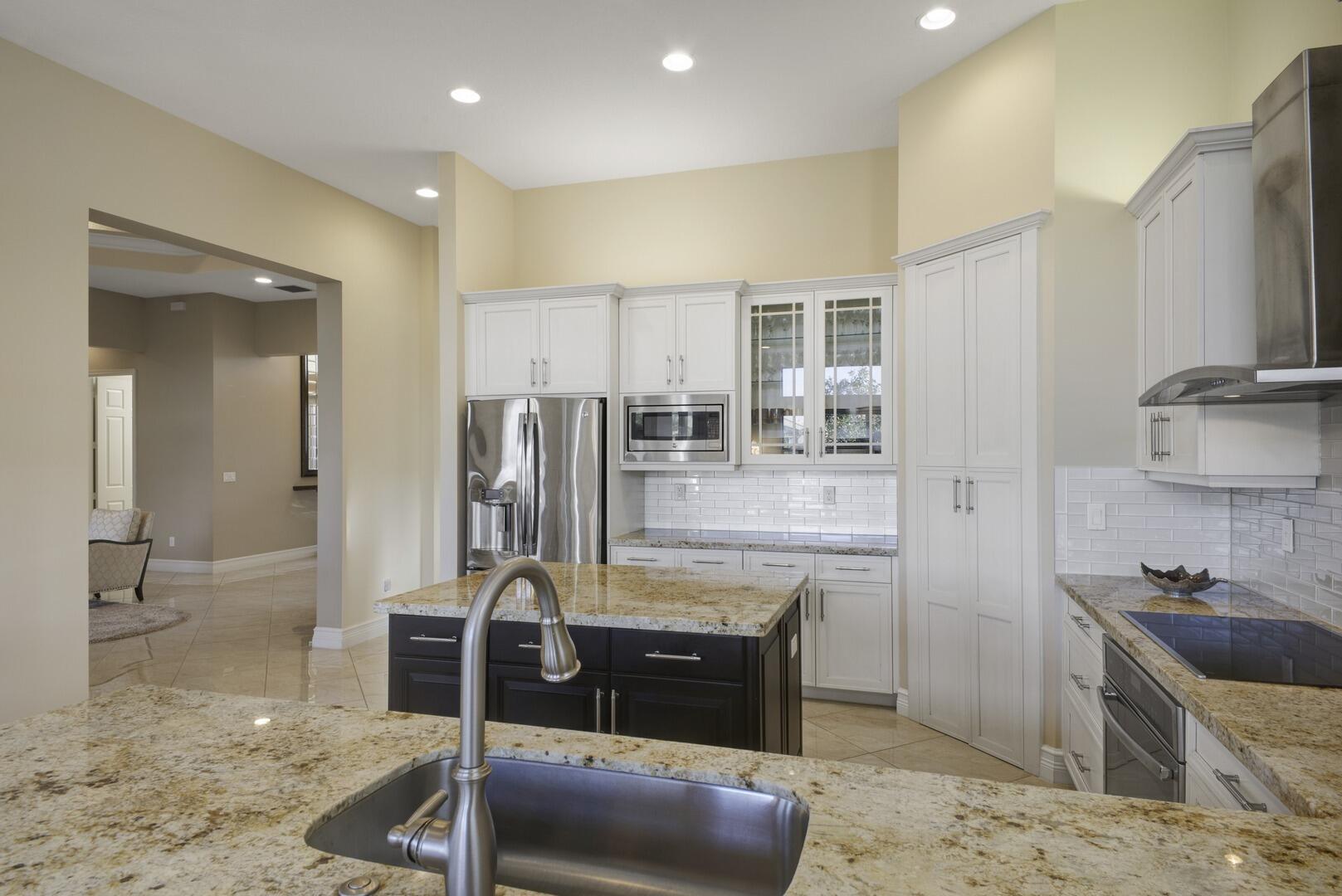 8289 Razorback Court Boynton Beach, FL 33473 - Photo 11 of 51 a kitchen with stainless steel appliances kitchen island granite countertop a sink and cabinets