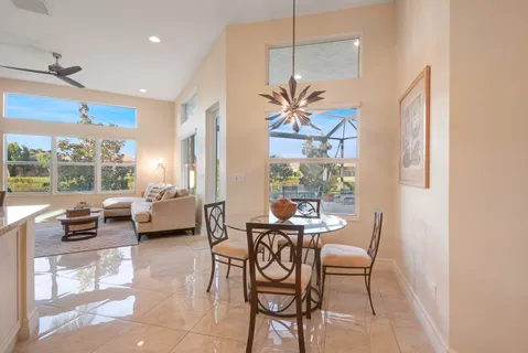 a kitchen with stainless steel appliances granite countertop wooden cabinets a dining table and chairs