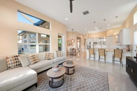 a kitchen with stainless steel appliances kitchen island granite countertop a table chairs and a refrigerator