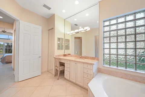 a spacious bathroom with a tub sink and mirror