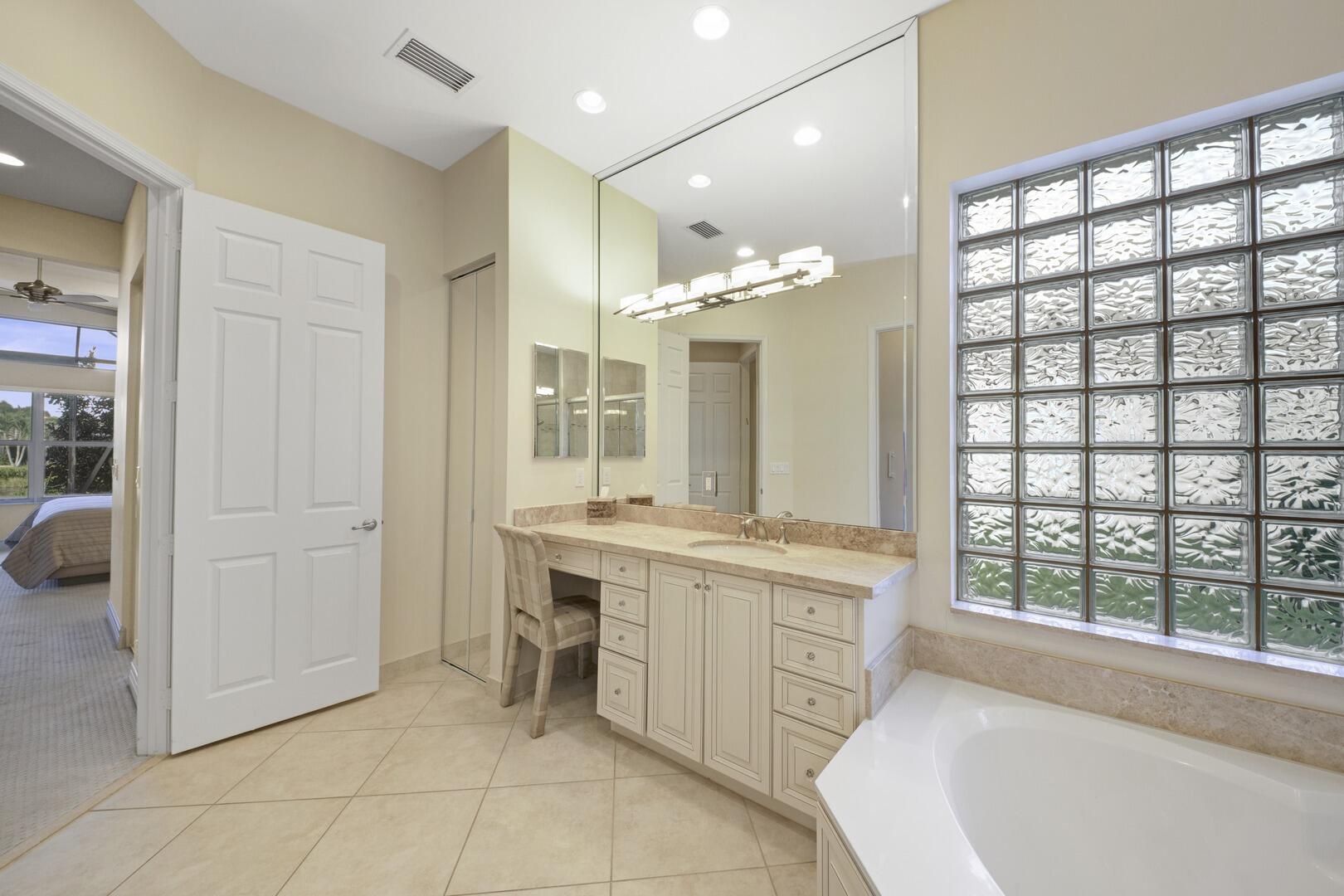 8289 Razorback Court Boynton Beach, FL 33473 - Photo 22 of 51 a spacious bathroom with a tub sink and mirror