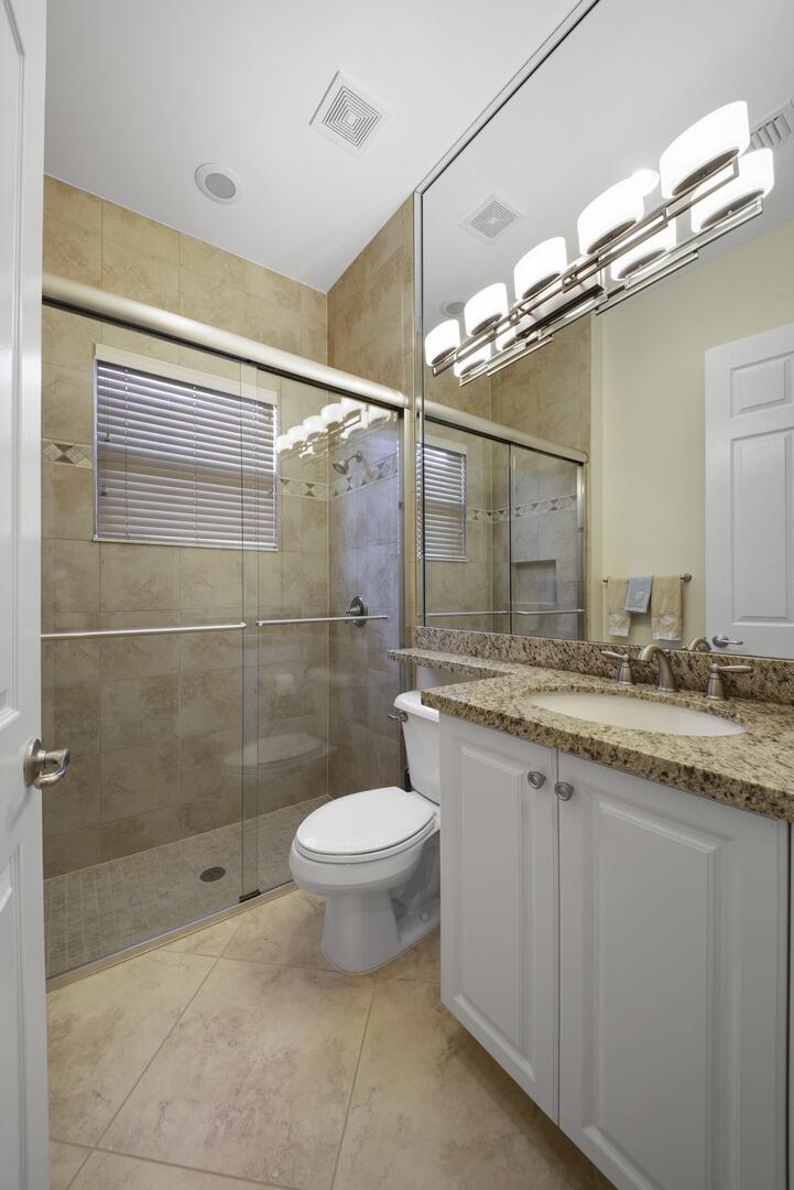 8289 Razorback Court Boynton Beach, FL 33473 - Photo 24 of 51 a bathroom with a granite countertop sink a toilet and shower