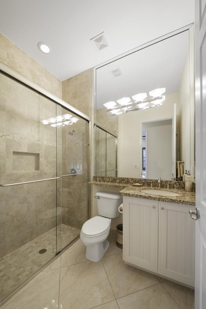 8289 Razorback Court Boynton Beach, FL 33473 - Photo 27 of 51 a bathroom with a granite countertop sink a toilet and a shower