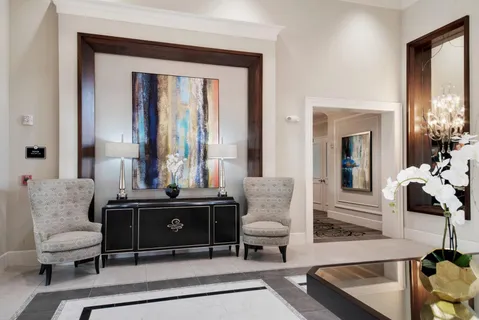 a living room with furniture and a large mirror next to a window