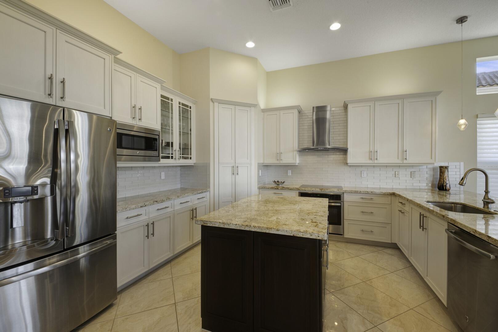 8289 Razorback Court Boynton Beach, FL 33473 - Photo 9 of 51 a kitchen with stainless steel appliances granite countertop a refrigerator sink and white cabinets