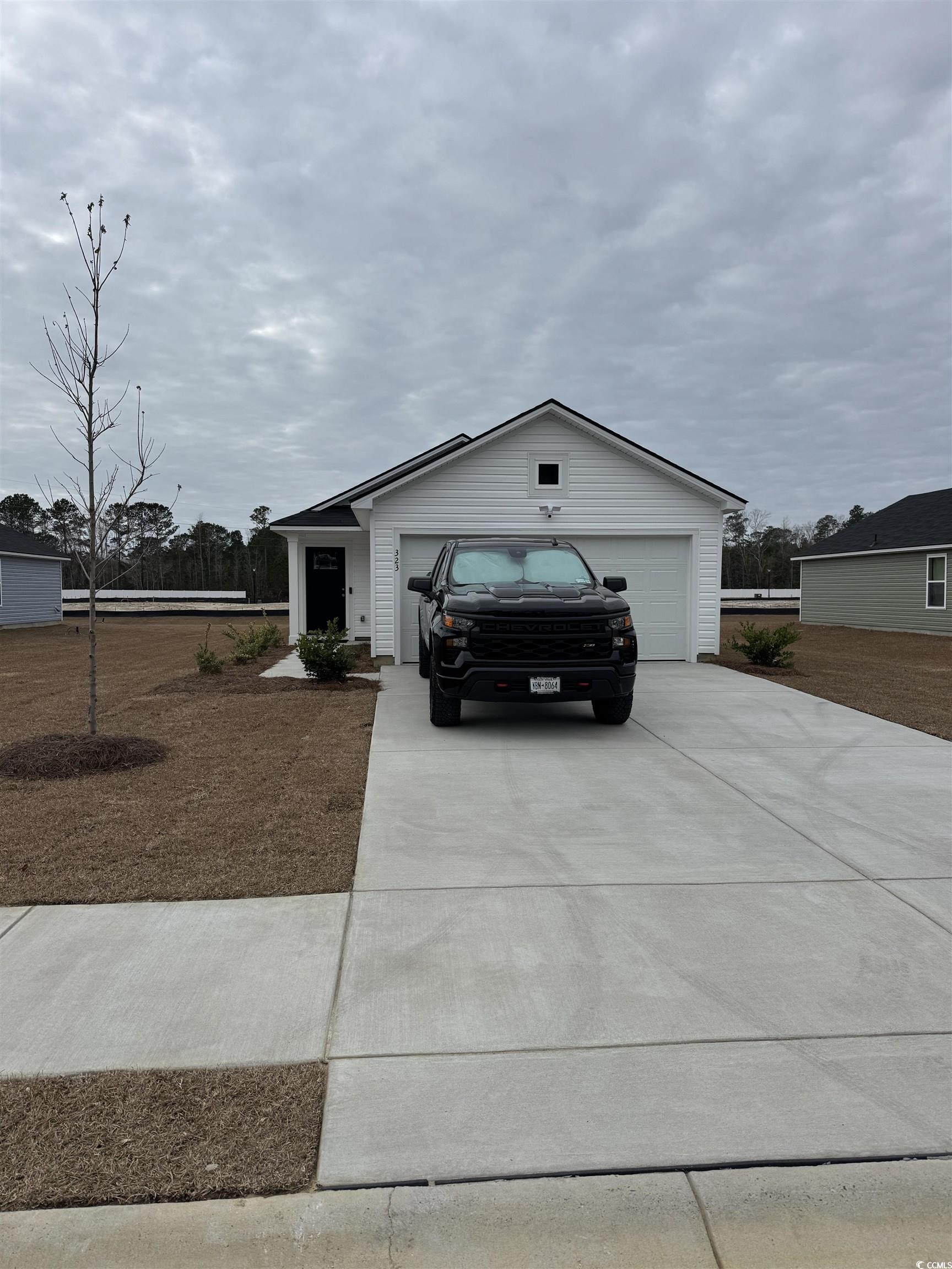 View of front of property with concrete driveway and an attached garage