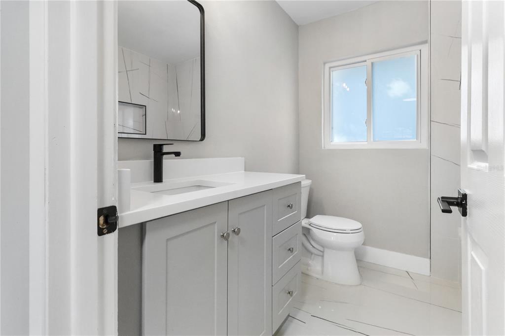 772 Palmer Road Belleair Bluffs, FL 33770 - Photo 17 of 26 a bathroom with a toilet sink and mirror