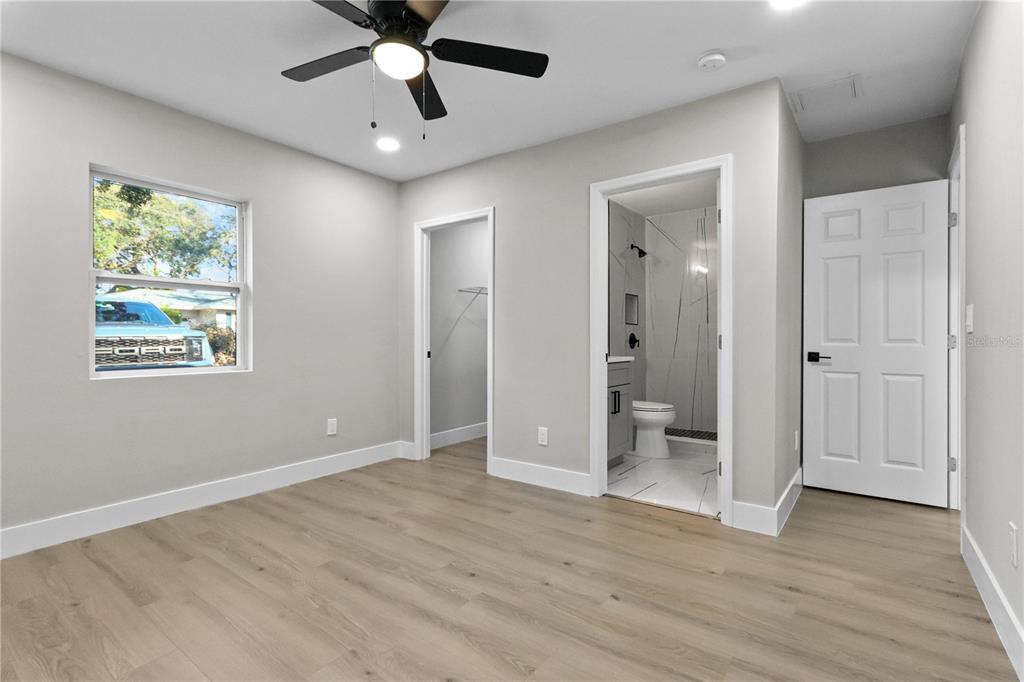 772 Palmer Road Belleair Bluffs, FL 33770 - Photo 19 of 26 wooden floor in an empty room with a bathroom