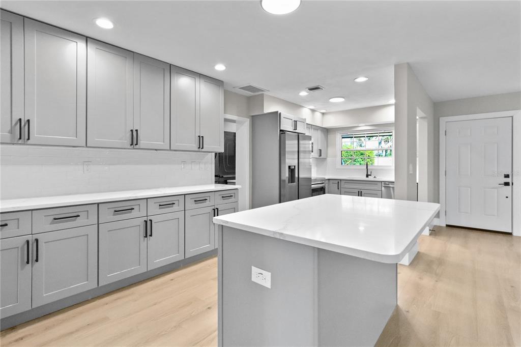 772 Palmer Road Belleair Bluffs, FL 33770 - Photo 9 of 26 a kitchen with kitchen island a sink stove and refrigerator