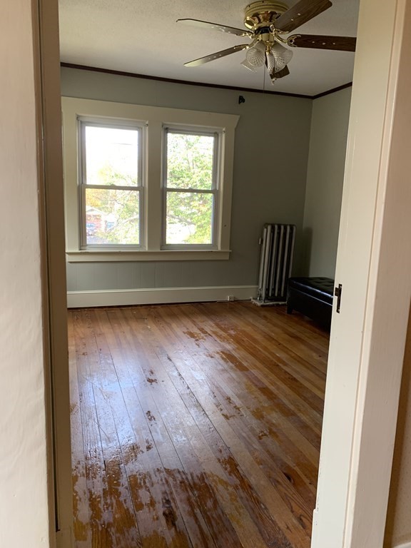 229 Fountain Street Springfield, MA 01108 - Photo 12 of 18 an empty room with wooden floor fan and windows