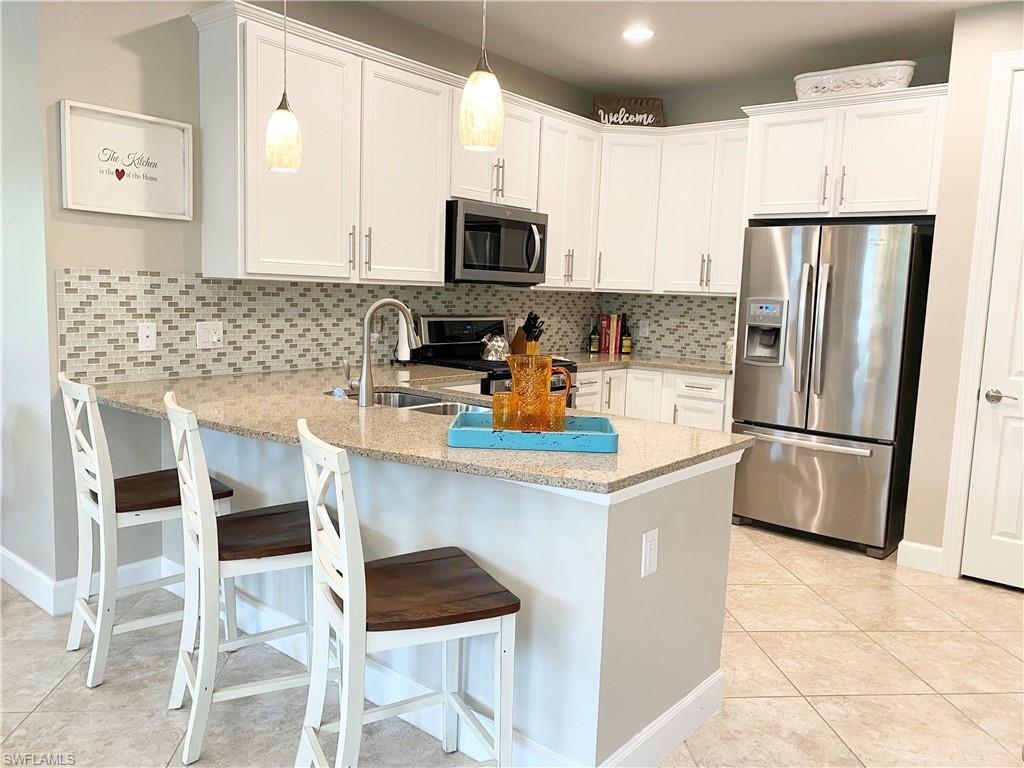 a kitchen with stainless steel appliances a refrigerator stove microwave and cabinets
