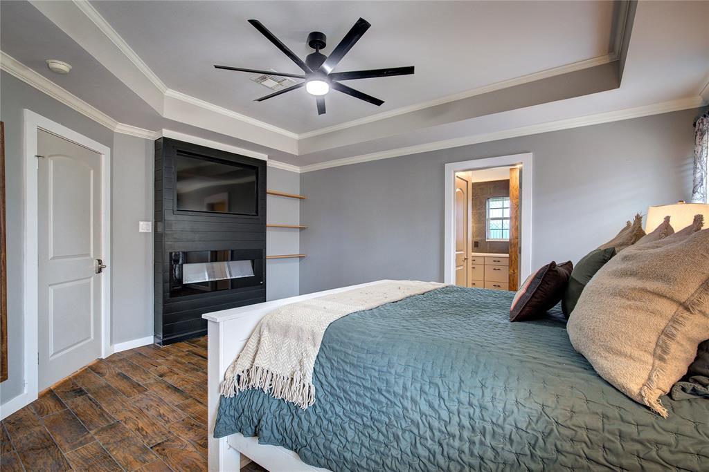 2027 Park Springs Road Sulphur Springs, TX 75482 - Photo 19 of 39 a bedroom with a large bed and a chandelier