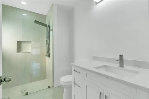 a bathroom with a sink a toilet and shower