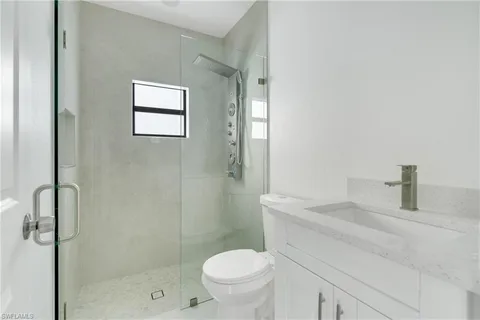 a bathroom with a toilet sink vanity and shower