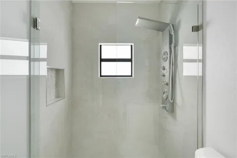 a bathroom with a window and a shower