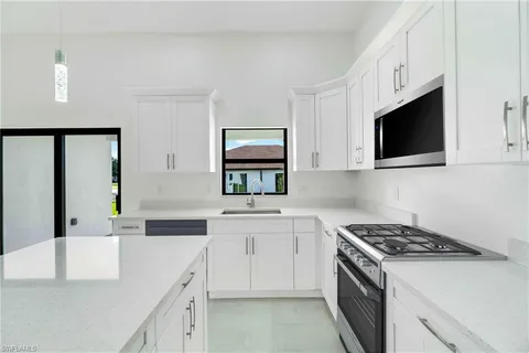 a kitchen with stainless steel appliances white cabinets and a stove top oven