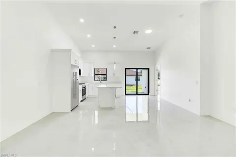 a view of kitchen with furniture and refrigerator