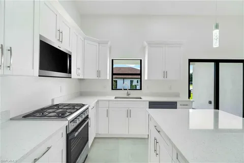 a kitchen with stainless steel appliances white cabinets and a stove top oven