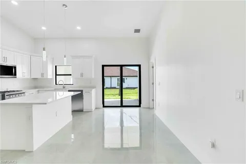 a large kitchen with a white stove top oven and white cabinets