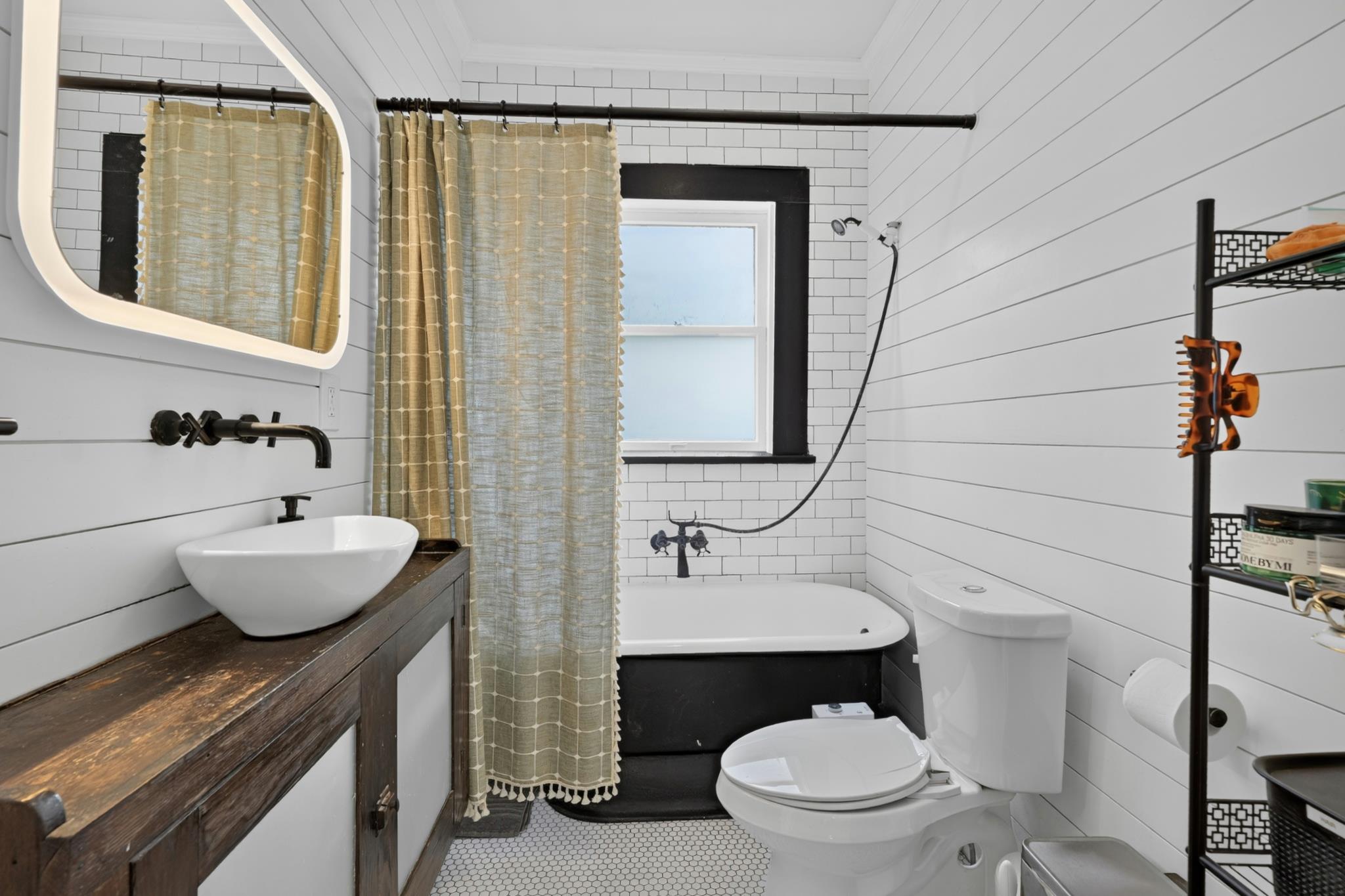 307 East 35th Street, Unit A Austin, TX 78705 - Photo 28 of 40 A well-appointed bathroom features a pedestal sink, soaking tub, and subway tile accents.