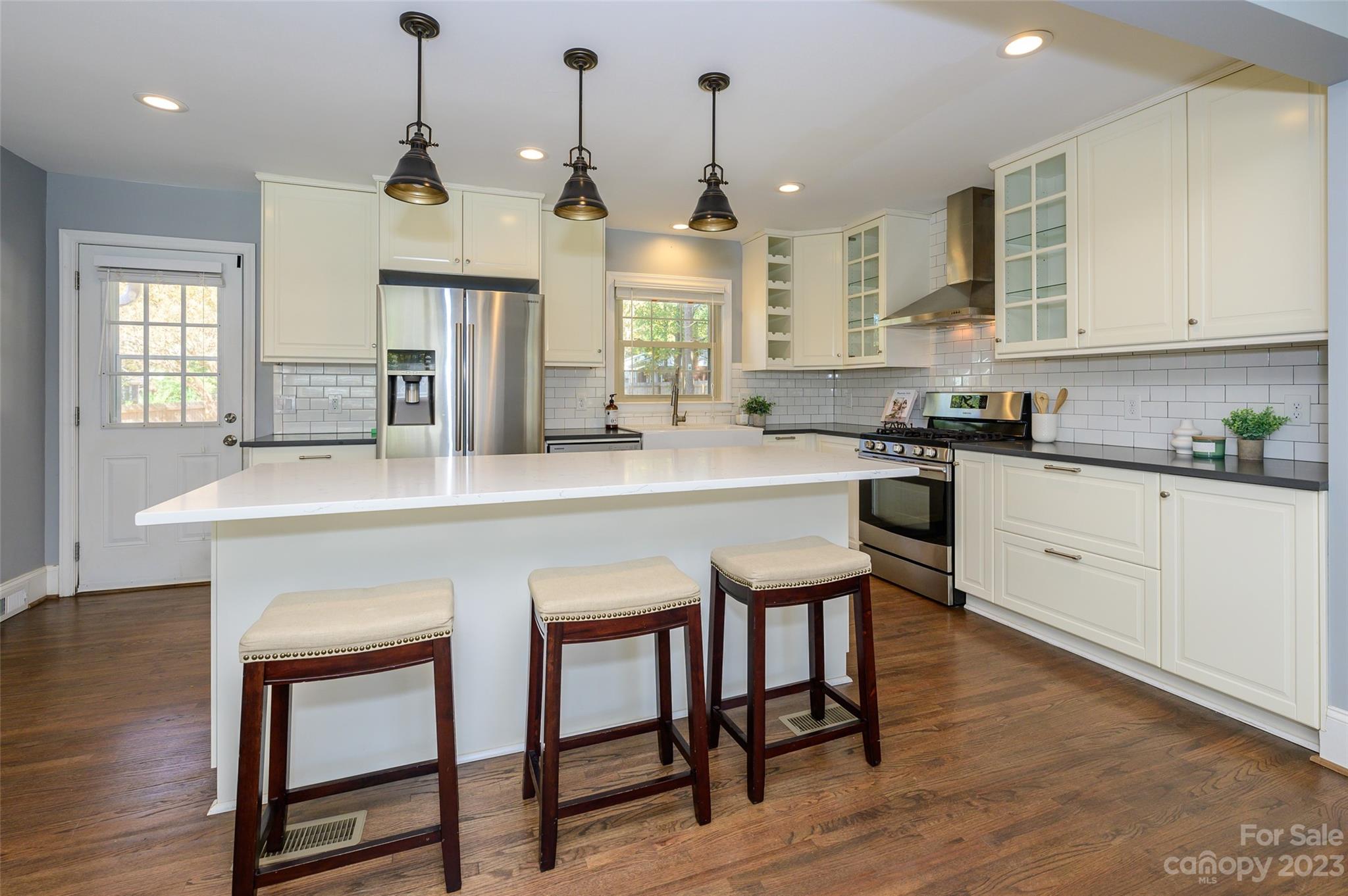 2901 Enfield Road Charlotte, NC 28205 - Photo 11 of 29 a kitchen with stainless steel appliances granite countertop a kitchen island hardwood floor sink stove dining table and chairs