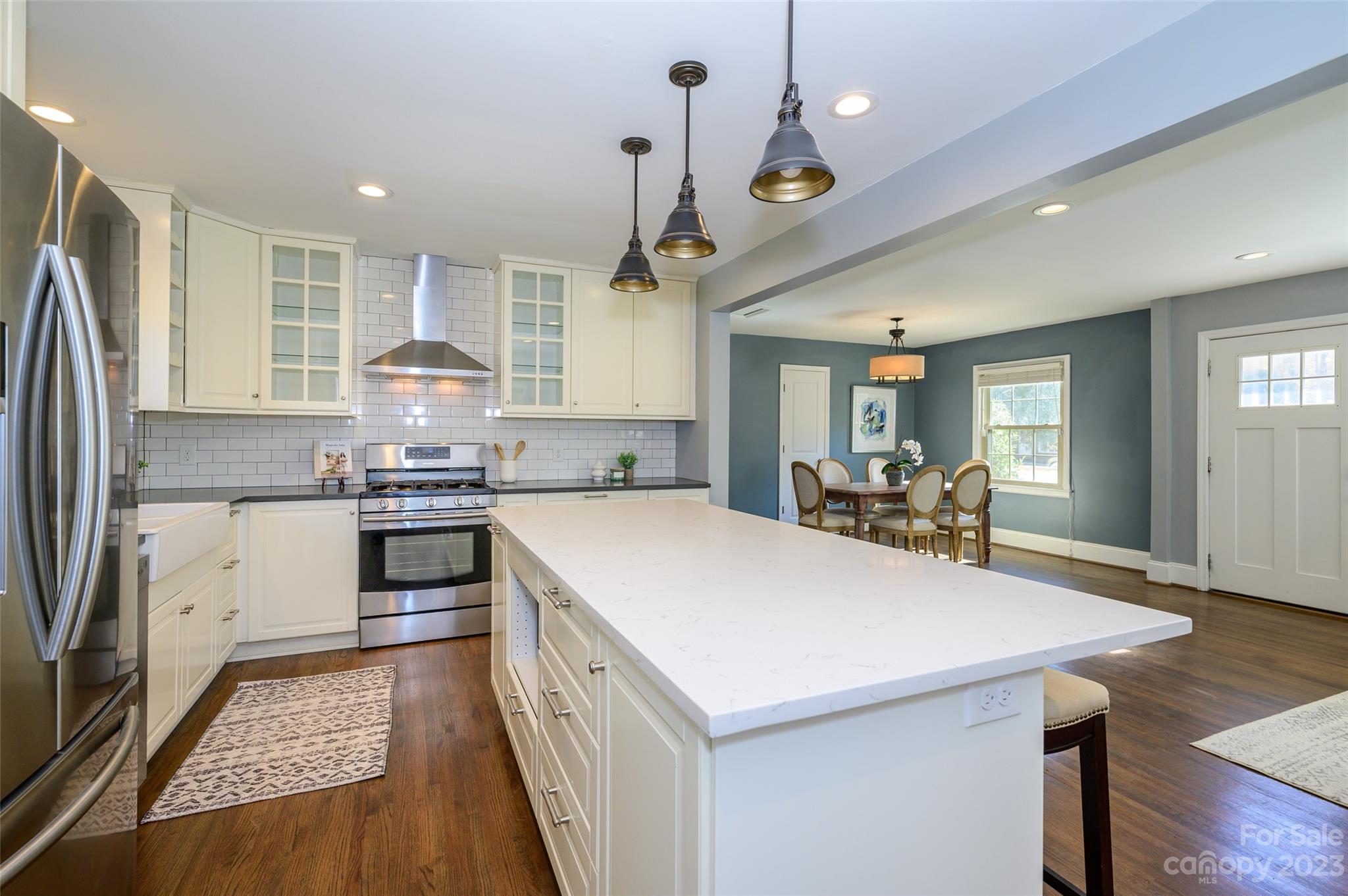 2901 Enfield Road Charlotte, NC 28205 - Photo 14 of 29 a kitchen with kitchen island a stove a sink a refrigerator and chairs