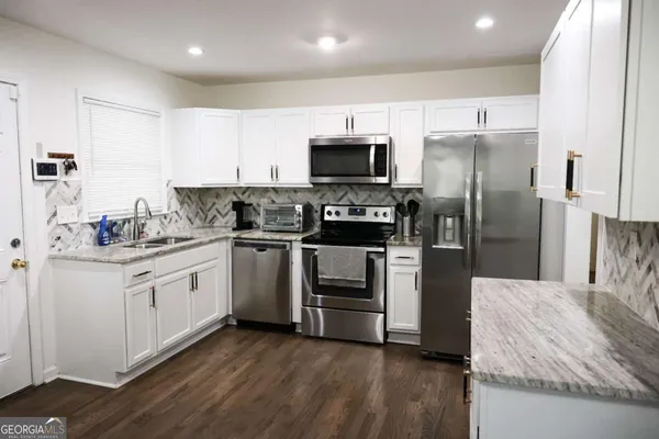 a kitchen with stainless steel appliances a refrigerator a stove a microwave and cabinets