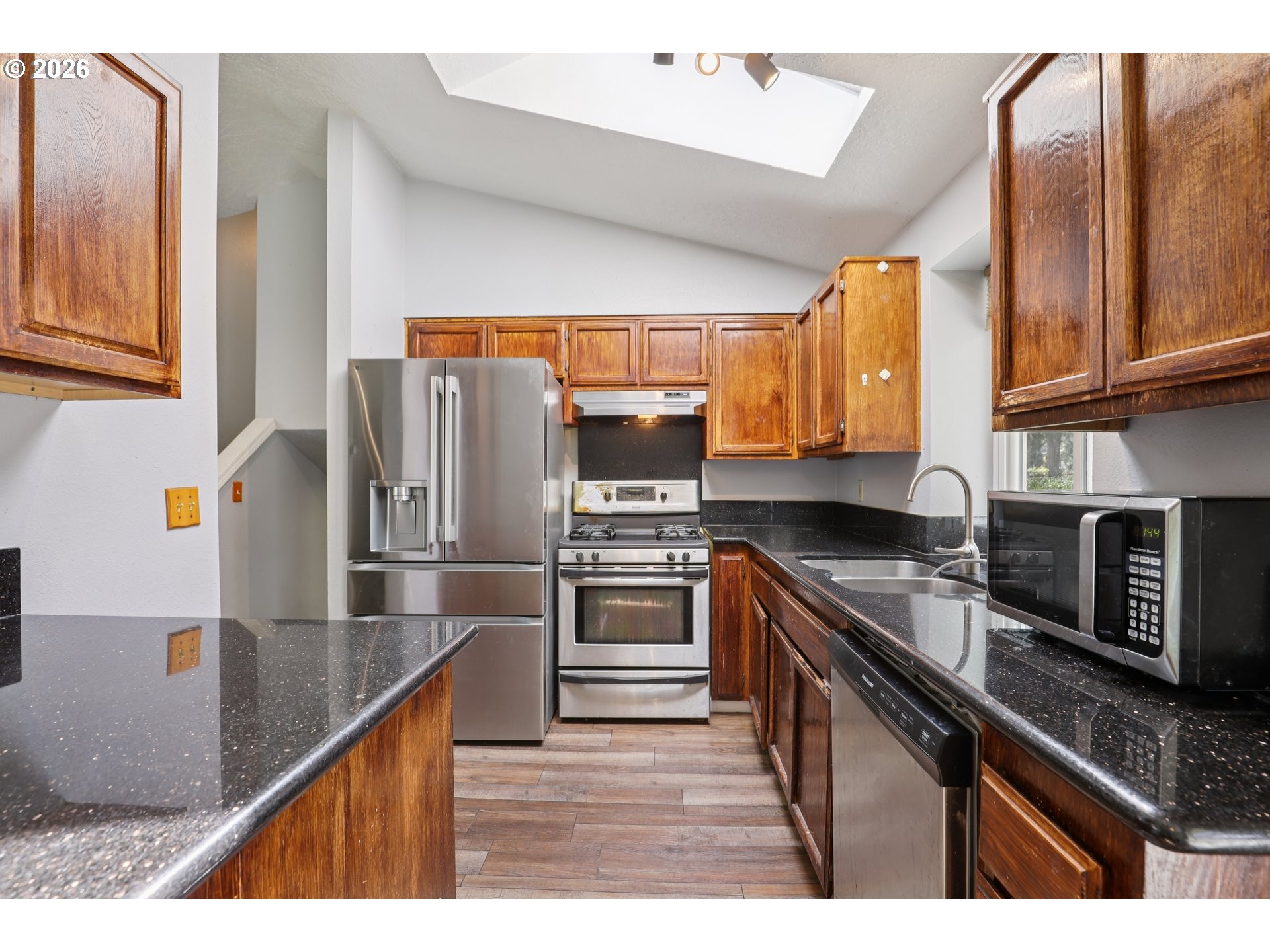 691 Southwest Linneman Court Gresham, OR 97030 - Photo 12 of 35 a kitchen with stainless steel appliances granite countertop a sink a stove and a refrigerator