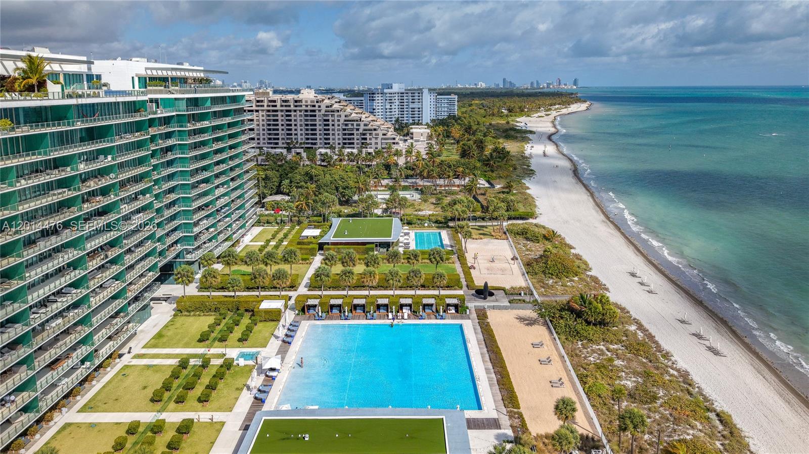 360 Ocean Drive, Unit 1106S Key Biscayne, FL 33149 - Photo 39 of 67 Aerial Exterior / Beachfront Setting – This elevated exterior view captures the building, pool deck, landscaped grounds, and direct beachfront setting. The coastline, turquoise water, and surrounding greenery highlight the property’s coastal location.