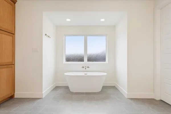 a spacious bathroom with a bathtub sink and mirror