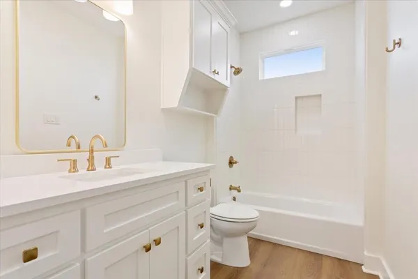 an empty room with a hardwood and ceiling fan