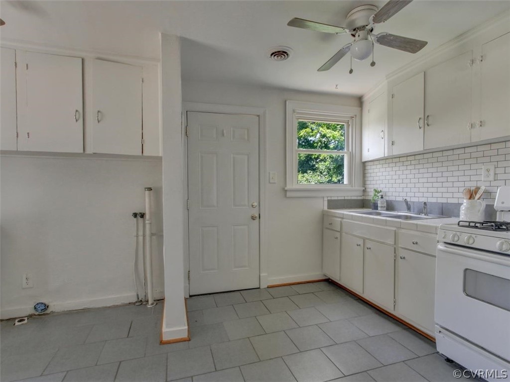 514 Riverview Road Colonial Heights, VA 23834 - Photo 7 of 17 a kitchen with white cabinets a sink a window and stainless steel appliances