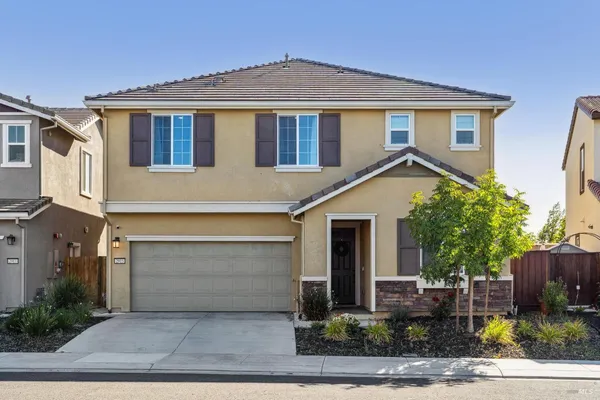 a front view of a house with a yard and garage