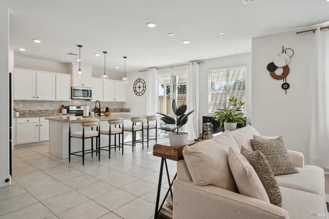 a living room with furniture and a dining table with kitchen view