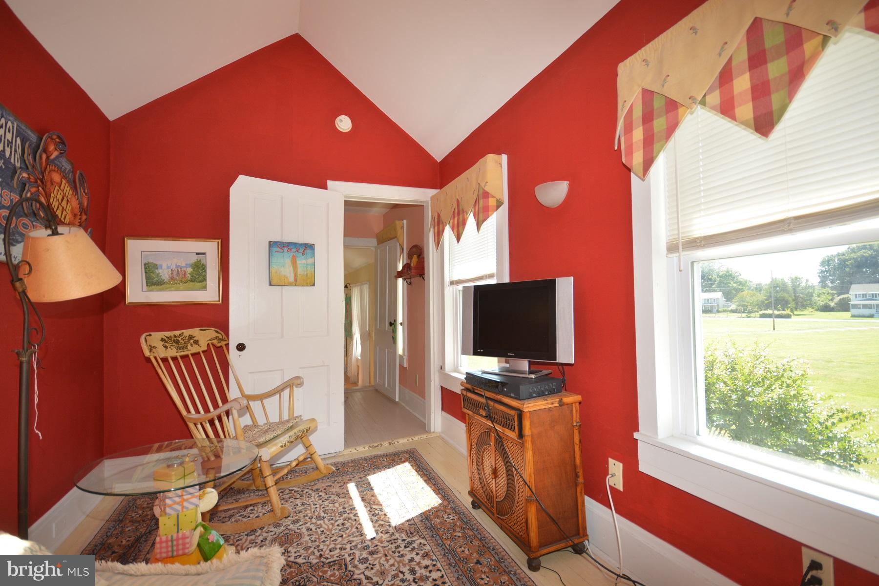 7967 Quaker Neck Road Bozman, MD 21612 - Photo 12 of 21 a living room with furniture a flat screen tv and a window