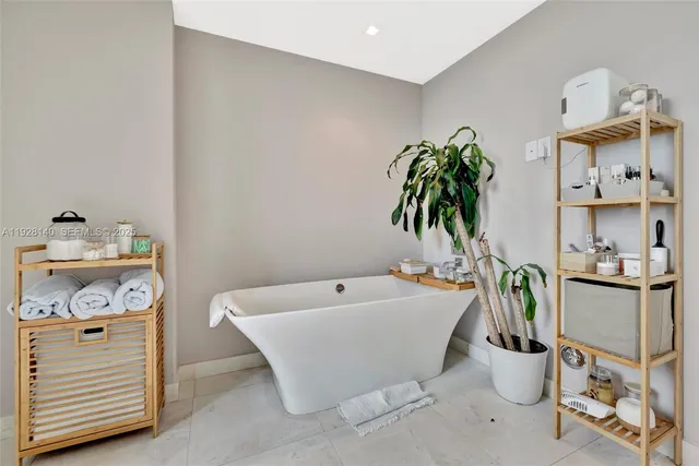 a bathroom with a sink a potted plant and a mirror
