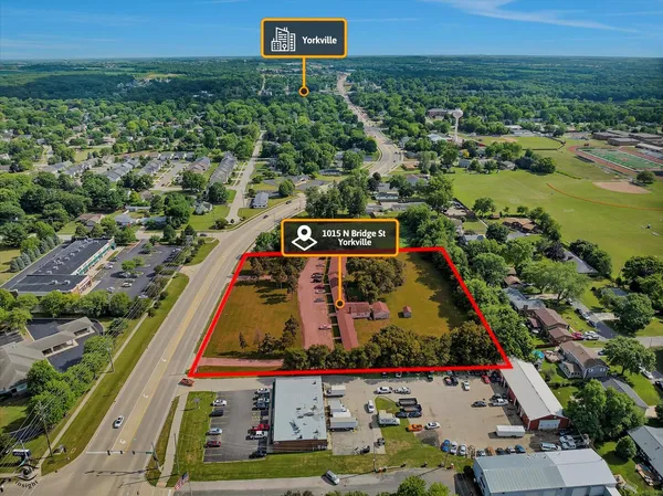 an aerial view of residential houses with outdoor space and trees