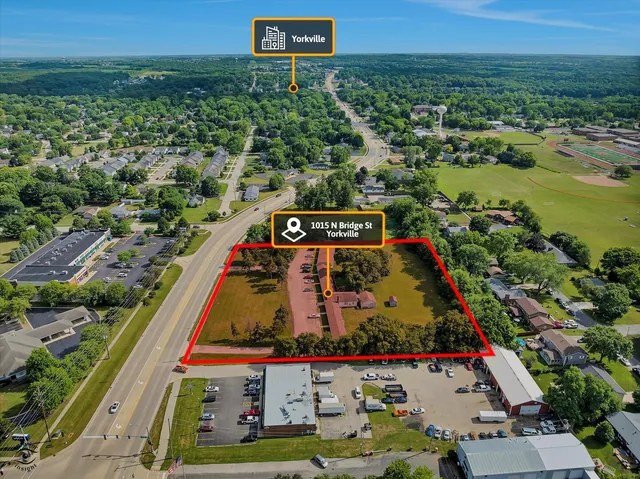 an aerial view of residential houses with outdoor space and trees