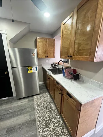 a kitchen with stainless steel appliances a sink a stove a refrigerator a sink a counter space and cabinets