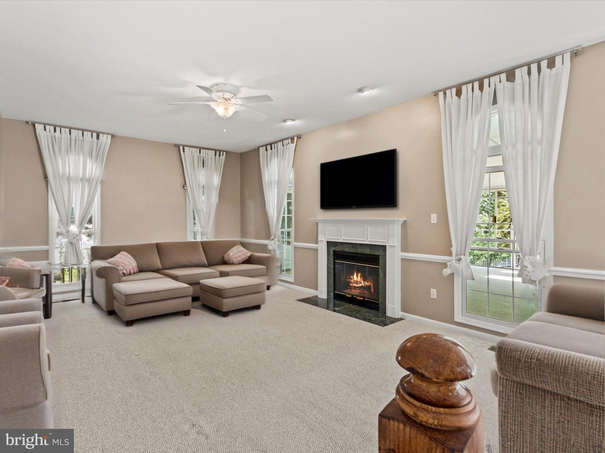 1505 Ridge Forest Way Hanover, MD 21076 - Photo 13 of 40 a living room with furniture a fireplace and a flat screen tv