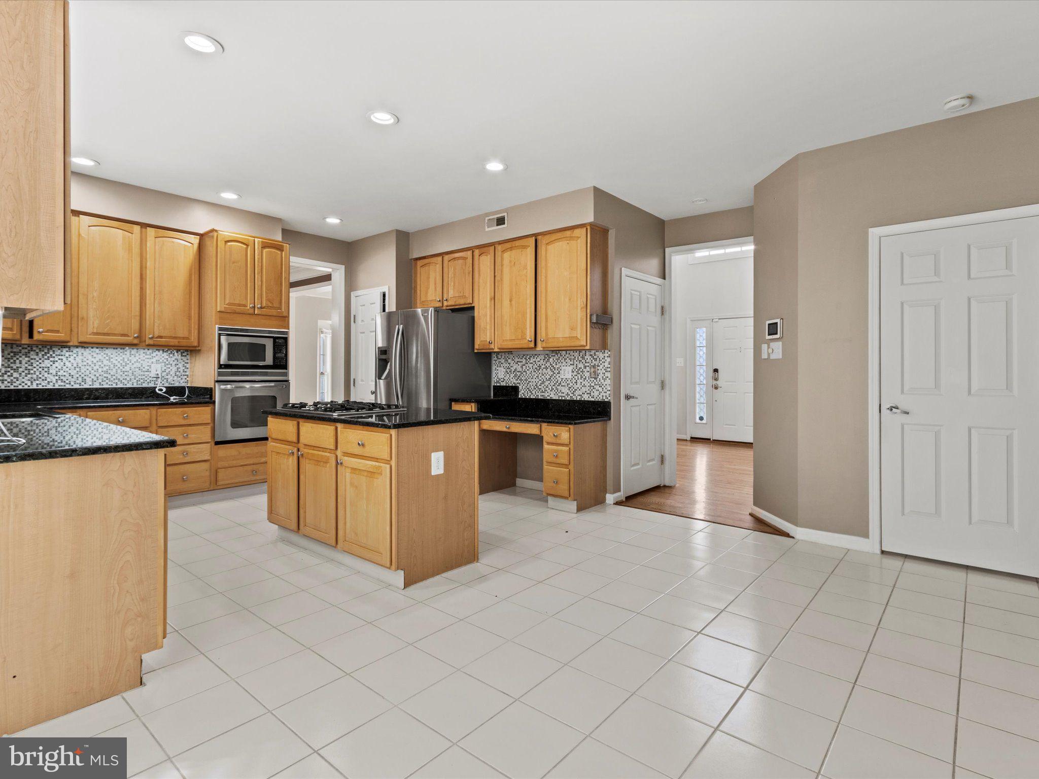 1505 Ridge Forest Way Hanover, MD 21076 - Photo 9 of 40 a large kitchen with a large counter top cabinets and stainless steel appliances